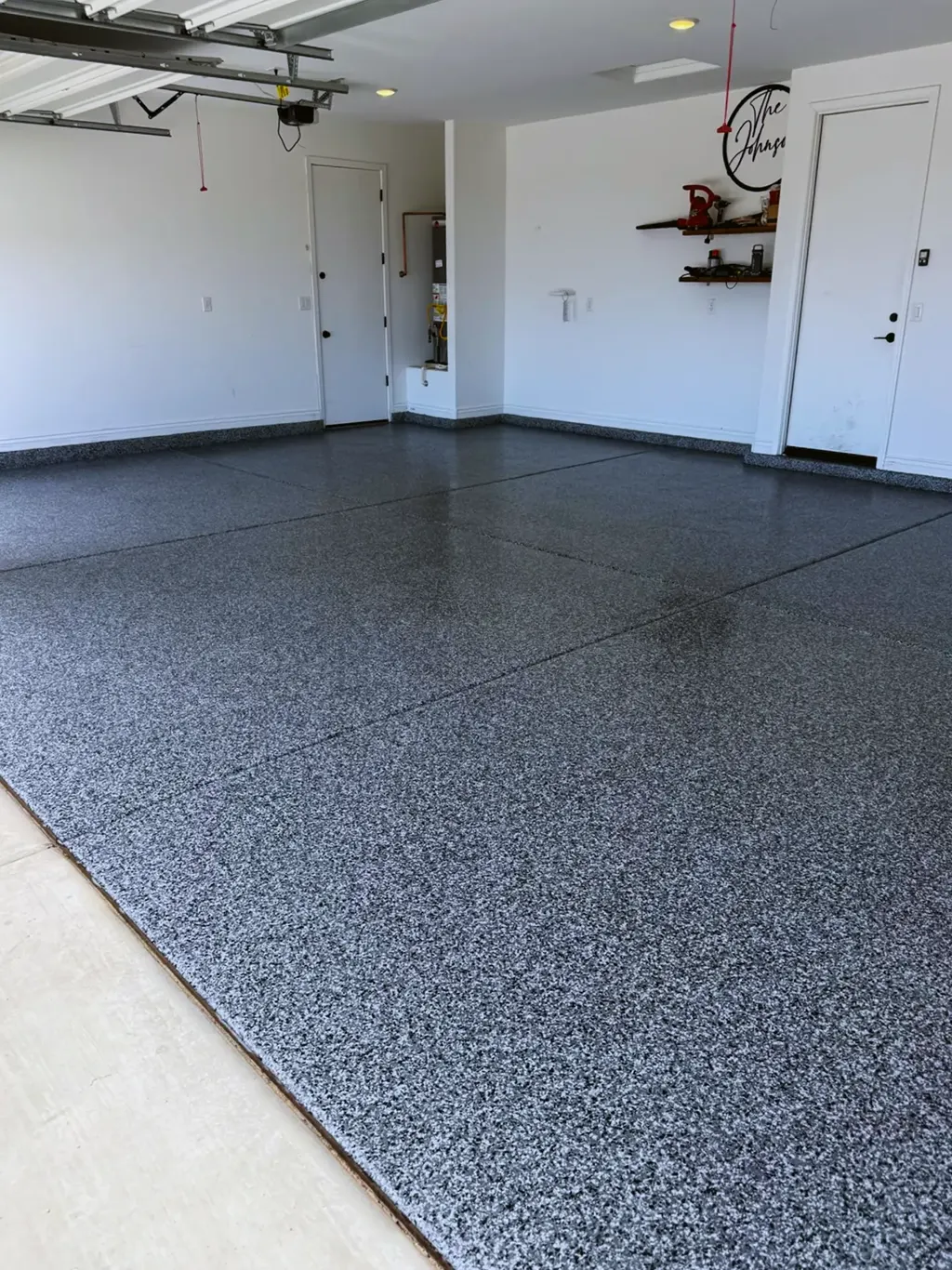 Coated garage floor with a white and gray flake finish and a clean coated cove along the walls.