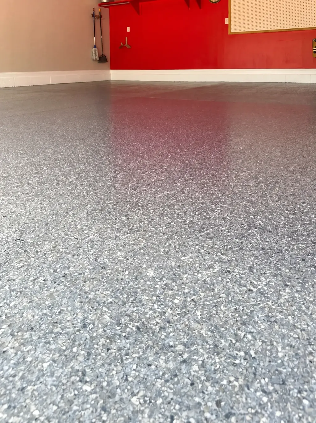 Low-angle view of a blue-gray flake garage floor showing dense flake coverage and a satin sheen.