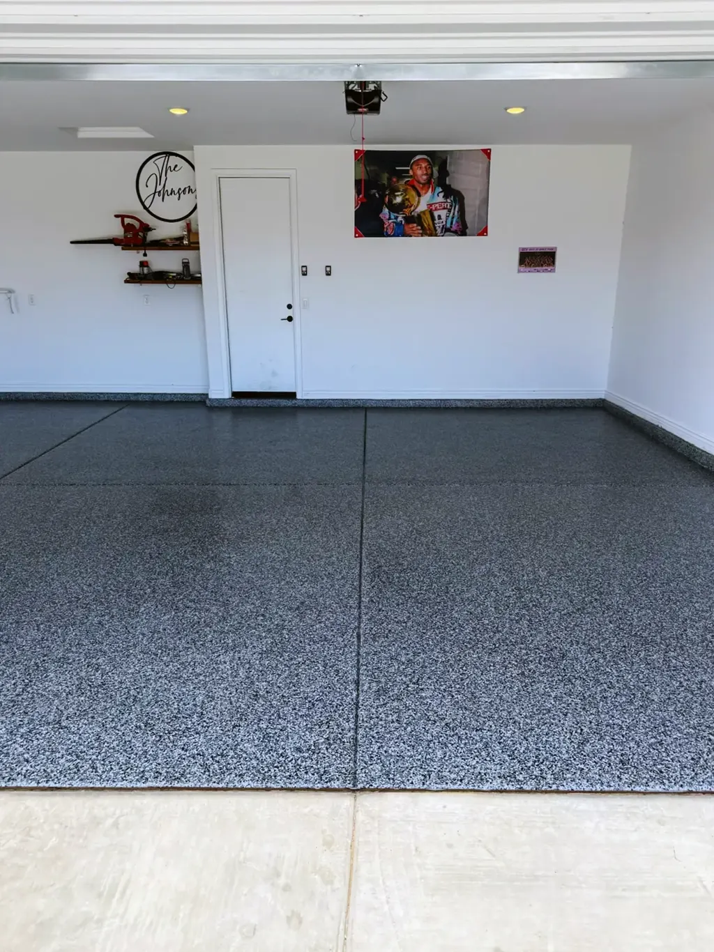 Finished garage floor coating seen from the driveway with an even flake blend across both bays.